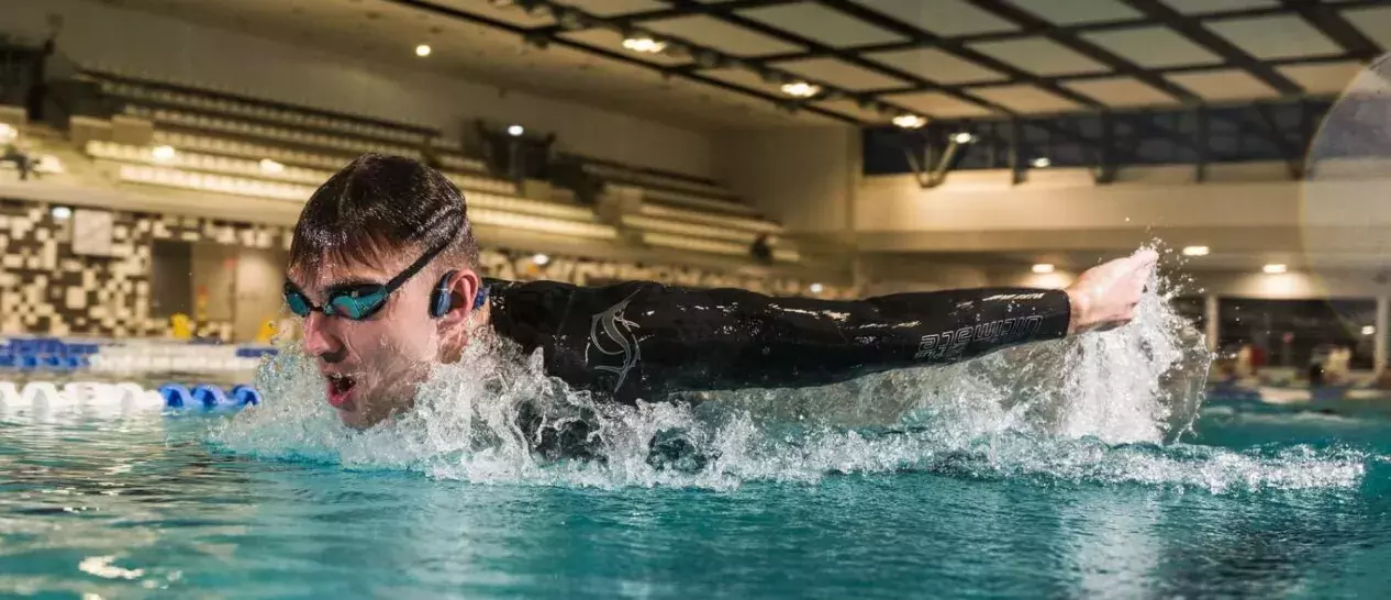 guy swimming on pool wearing CREATIVE Outlier Free Pro