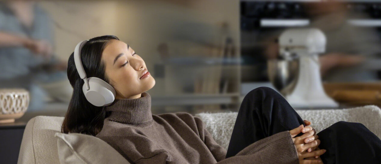 young woman listening to music with sony wh-1000mx5