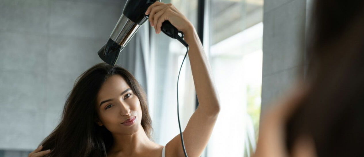 young woman using hair dryer