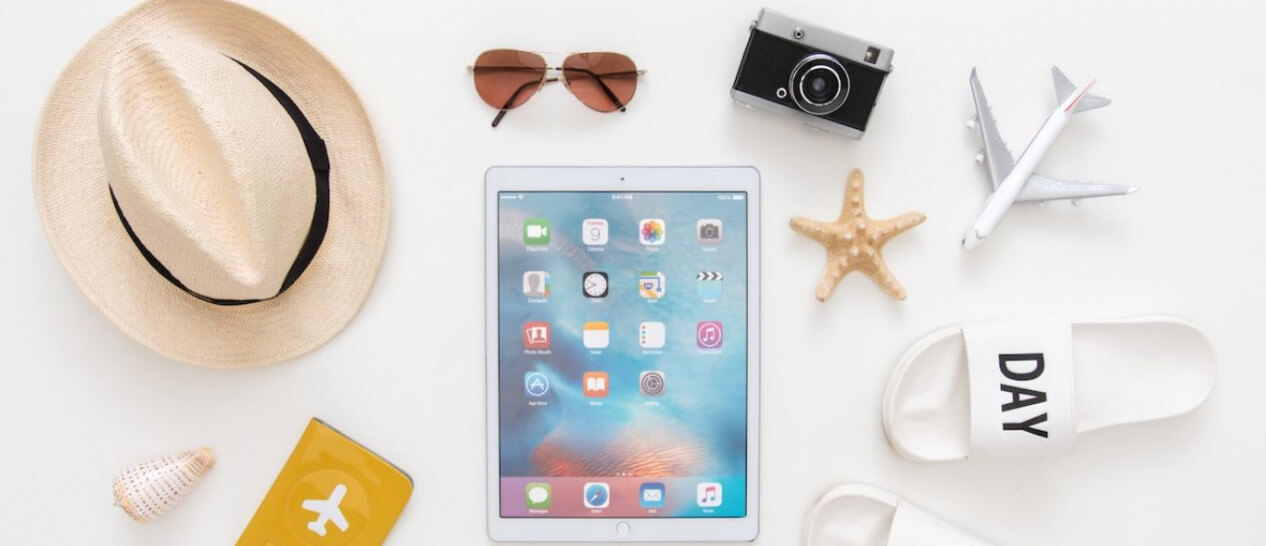 tablet with summer hat, sunglasses on table