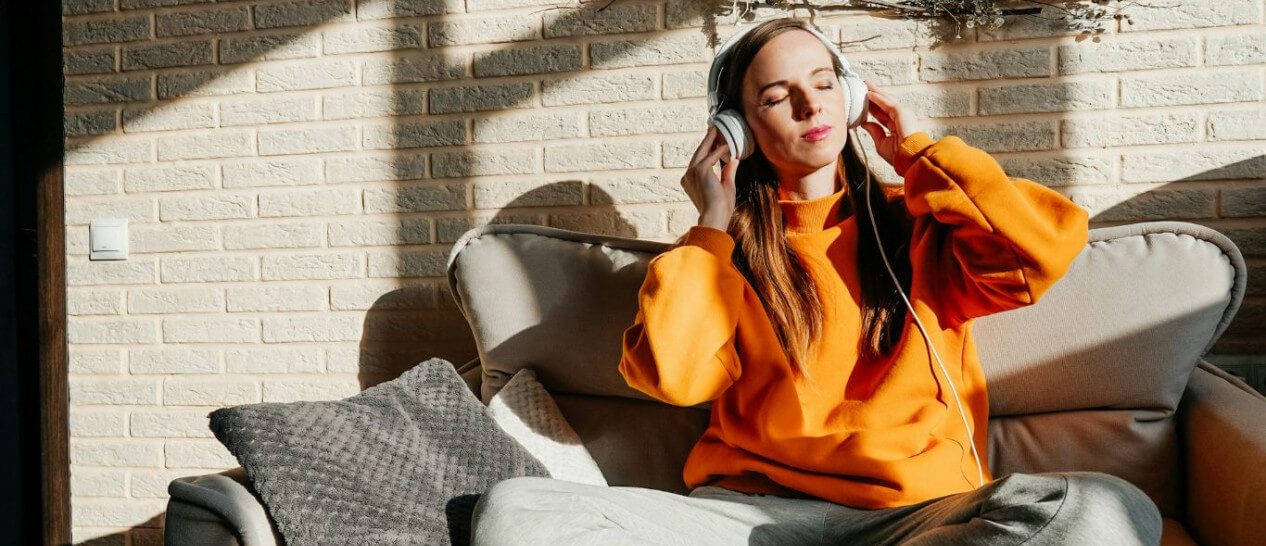 woman in orange with headphones