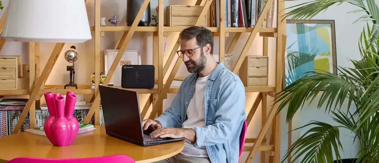 Ένας άνδρας κάνει δουλειά στο laptop του απολαμβάνοντας τα πλεονεκτήματα μίας σύνδεσης COSMOTE