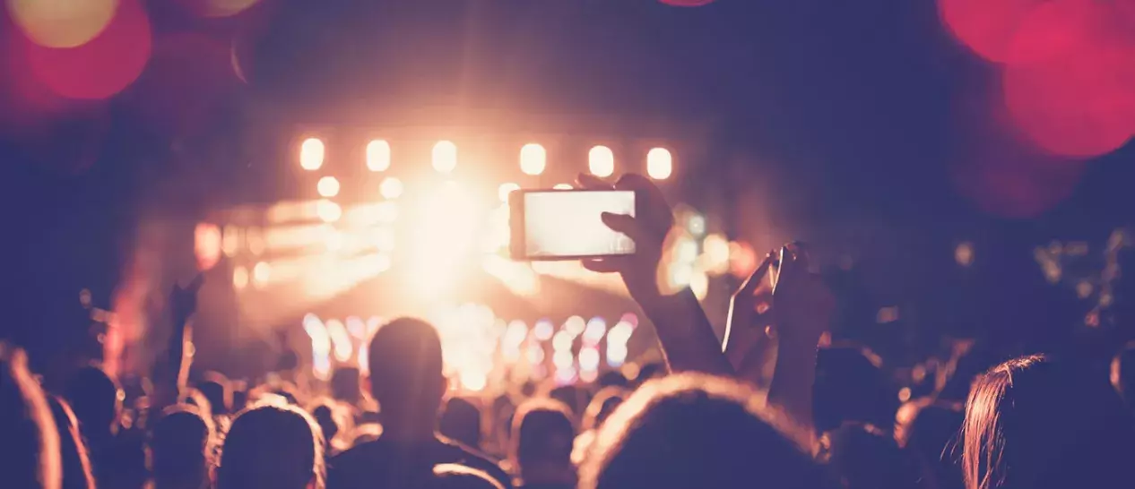 Ένας παρευρισκόμενος καταγράφει ένα live με το smartphone του