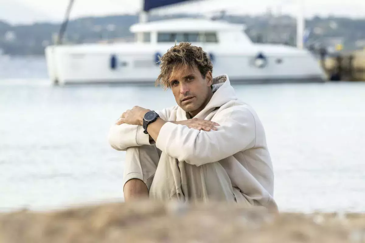 guy wearing GARMIN FĒNIX®️ 7 PRO SOLAR sitting on beach