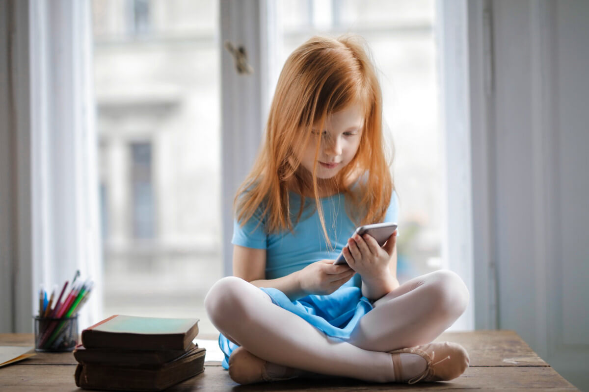 little redhead girl using smartphone