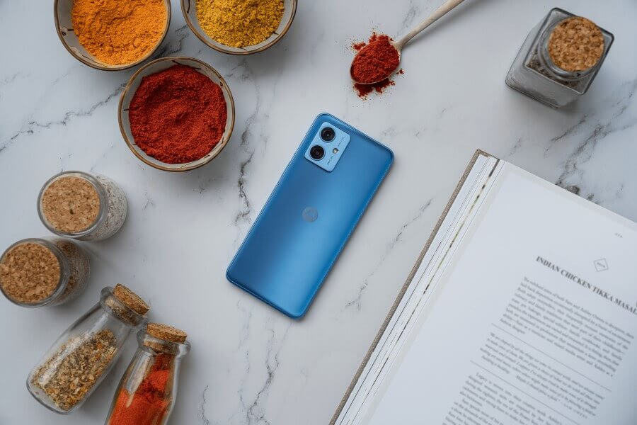 blue Moto G54 Power Edition on desk with spices