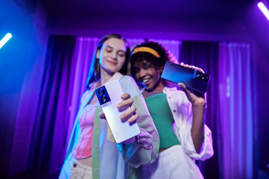 two girls holding TCL 40 NXTPAPER smartphones