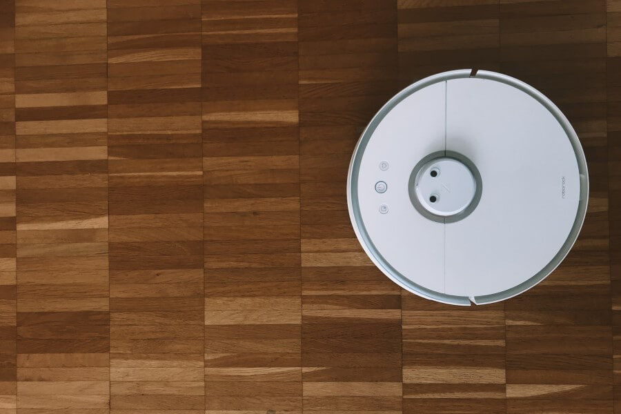 robot vacuum cleaner moving on wooden floor