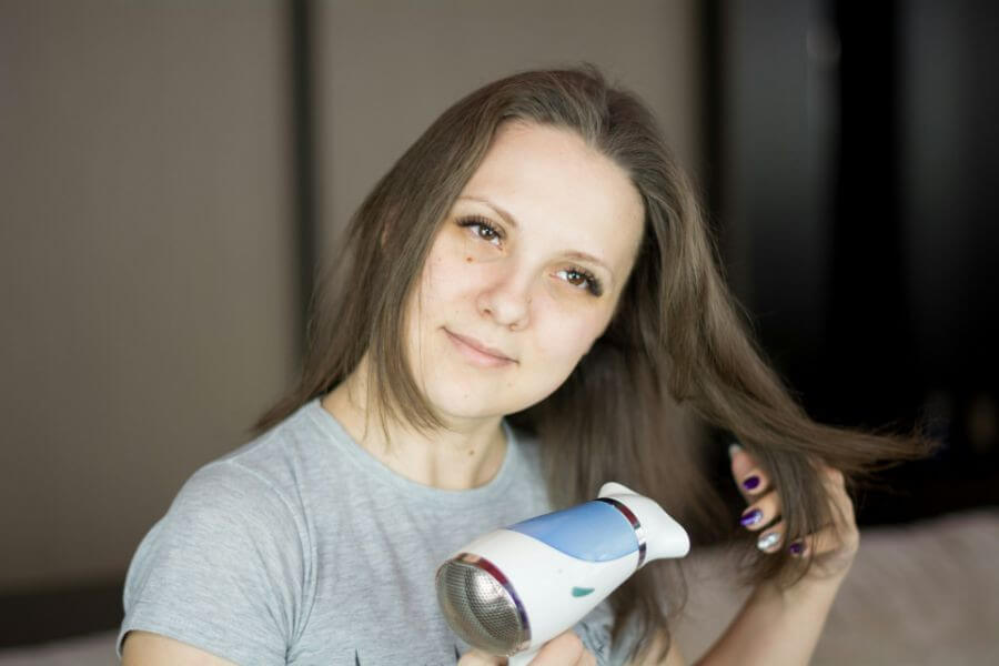 woman with straight hair using hair dryer