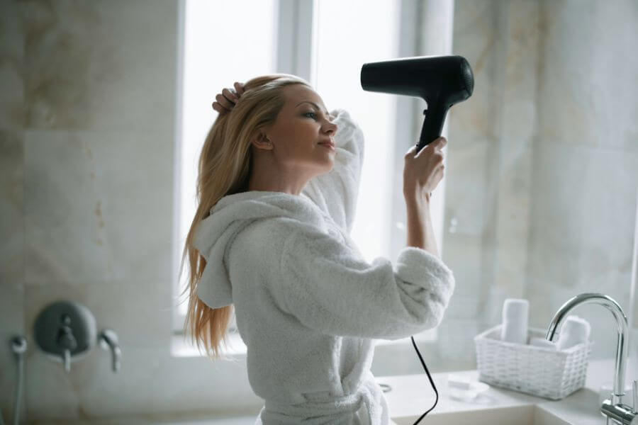 blonde woman with hair dryer