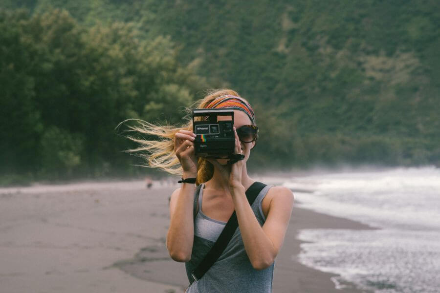 woman takes picture with polaroid camera