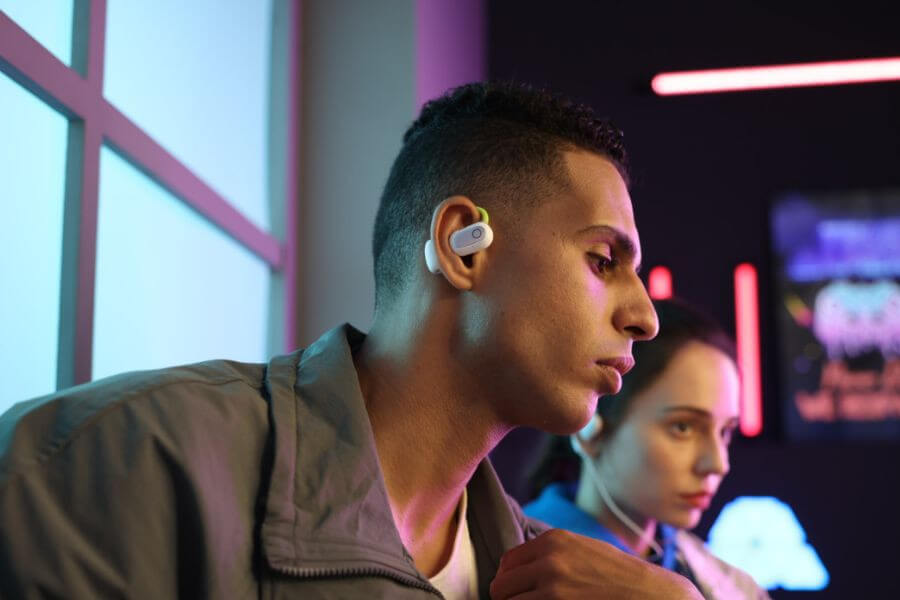 young guy wears open ear headphones