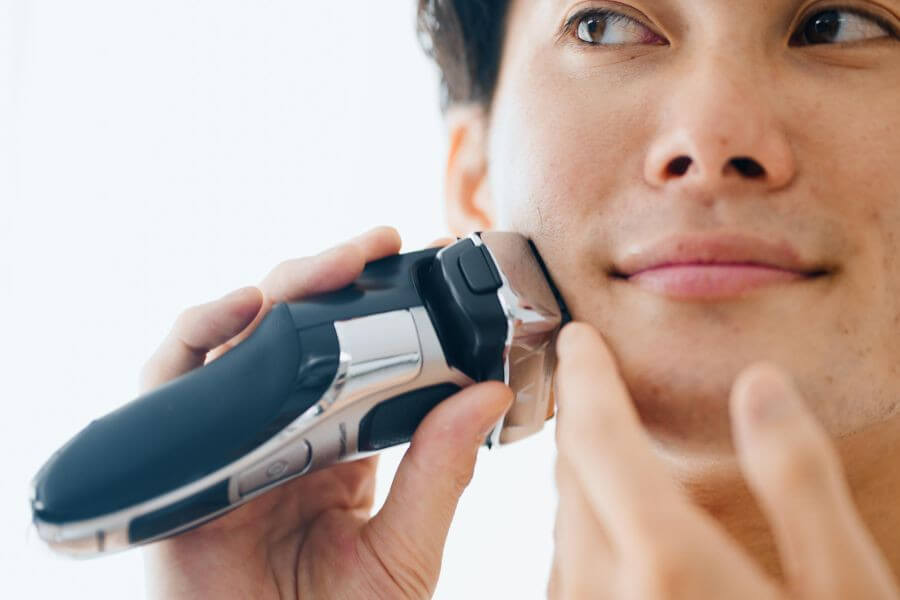 young guy shaving with trimmer