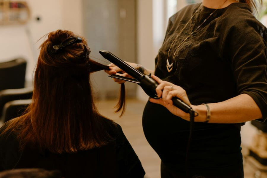 hairdresser uses hair straightener