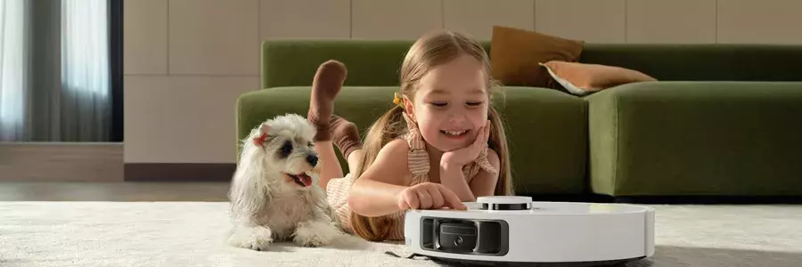 Ένα κοριτσάκι παίζει μαζί με τον σκύλο του και μία σκούπα ρομπότ