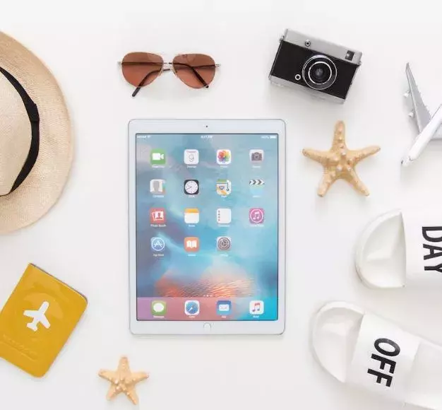 tablet with summer hat, sunglasses on table