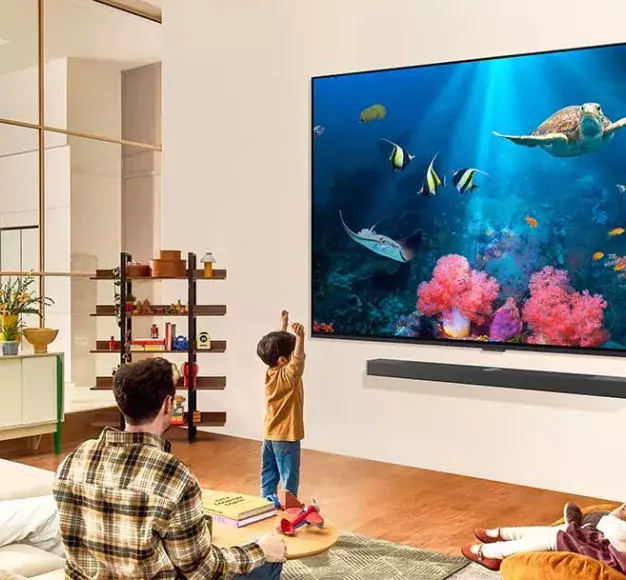 Μία οικογένεια παρακολουθεί τηλεόραση στη νέα της smart TV που αγόρασε από τον ΓΕΡΜΑΝΟ τη Black F...