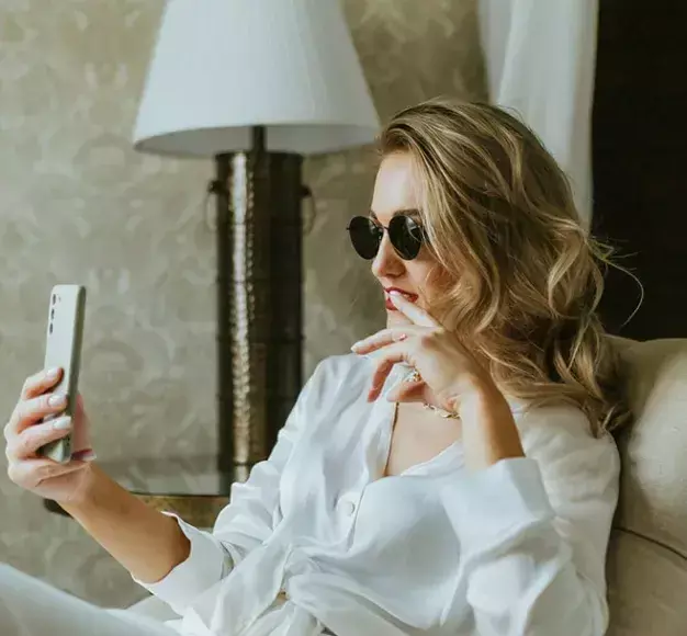 Μία γυναίκα χρησιμοποιεί το premium smartphone της που αγόρασε από τον ΓΕΡΜΑΝΟ