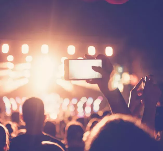 Ένας παρευρισκόμενος καταγράφει ένα live με το smartphone του